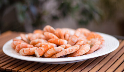 Tiger prawns on a large white plate, blurred background. Seafood.