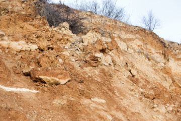 Rockslide. Mountain landslide in an environmentally hazardous area. Large cracks in earth, descent of large layers of earth blocking road. Mortal danger of dam at foot of landslide slopes of mountain