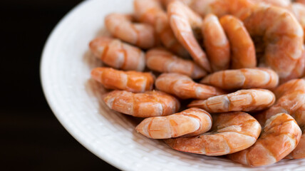 Tiger prawns on a large white plate, blurred background. Seafood.