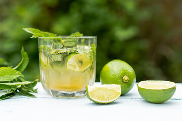 A glass of lemonade or a Mojito cocktail with lime and mint, a cold refreshing drink or a drink with ice. Summer concept. Cold detox water, copy space