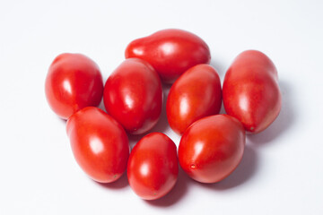 Tomatoes on a white background. Red tomatoes lie in a pile