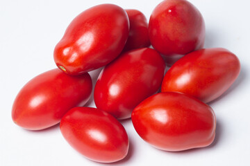 Tomatoes on a white background. Red tomatoes lie in a pile