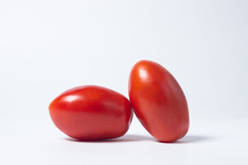 Tomatoes on a white background. Two red tomatoes lie next to each other