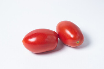 Tomatoes on a white background. Two red tomatoes lie next to each other