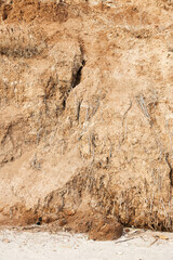 Background of mountain landslide in an environmentally hazardous area. Large cracks in the ground, the descent of soil layers, coquina. Deadly risk of coastal collapse