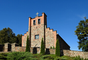 Fototapeta na wymiar built of field stone and brick in 1960, a Roman Catholic church dedicated to the Holy Cross in the village of weightlifting in Podlasie, Poland