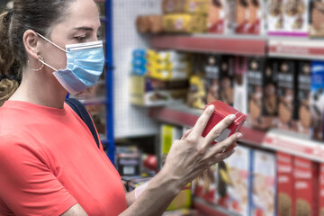 Mature woman wearing face protective mask buying groceries at supermarket.