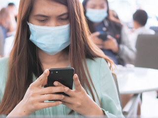 women wearing mask and holding the smartphone, new normal for business.