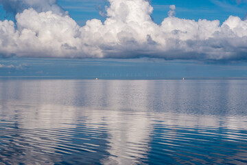 Naklejka na ściany i meble Wolkenspiegelung, bei spiegelglatter Nordsee,im Hintergrund Windräder.