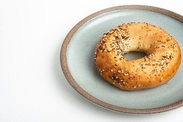 A Freshly Baked Single Bagel On A Ceramic Plate