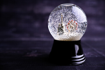 Frozen snow globe christmas magic ball with flying snowflakes and church and attraction. Winter...