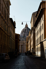 Durch eine Seitenstrasse in Rom hat man einen tollen Blick auf den beeindruckenden St. Petersdom, der im Zentrum des Vatikans steht.