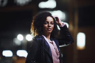 Fashionable woman on urban city street at night