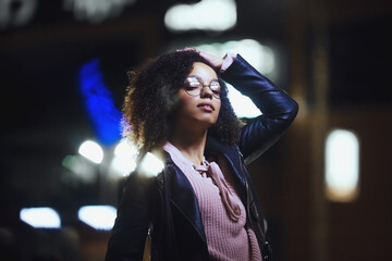 Fototapeta premium Black girl portrait in night city lights
