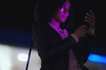 Fashionable woman on urban city street at night