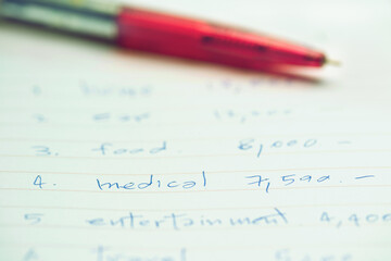 pen on white sheet with month budget for medical cost or to the treatment of illness