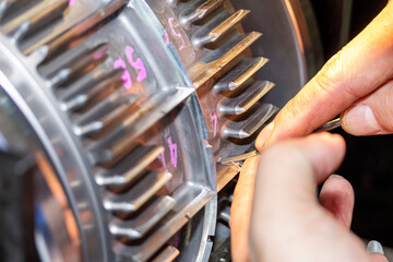 Close up hand of operator use a diamond file or equipment to polish and decorate blade of roller...
