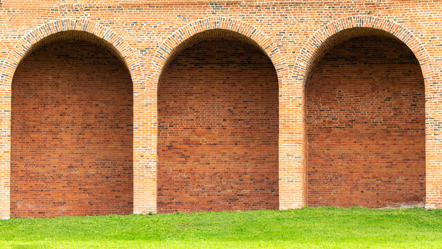 red brick wall with semicircular arches inside