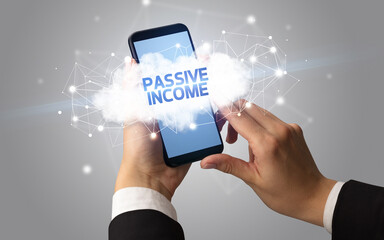 Female hand touching smartphone with PASSIVE INCOME inscription, cloud business concept