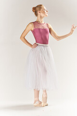Fototapeta na wymiar woman ballerina in pointe shoes and in a tutu on a light background poses posing legs dance model