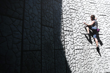 Man free climbing on a concrete wall