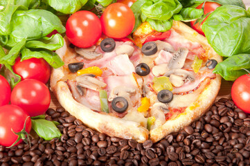 Closeup of pizza with coffee beans, tomatoes, cheese and basil