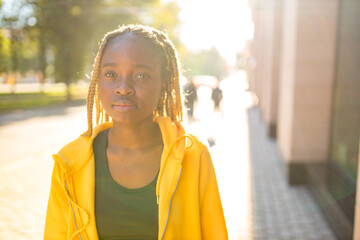 african american woman with long yellow dreadlocks pigtails looking sad and lonely in the street of sity