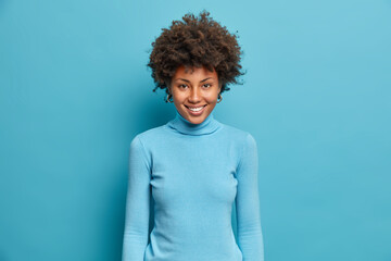 Shot of attractive cheerful Afro American woman rejoices nice day and smiles broadly, wears casual...