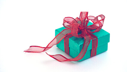Top angle view green glitter gift box with red ribbon on white background