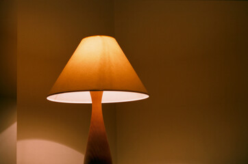 Beautiful floor lamp indoors in the evening near the yellow wall. The real grain of the scanned film.