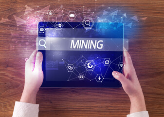 Close-up of a tablet searching MINING inscription, hi-tech computing concept