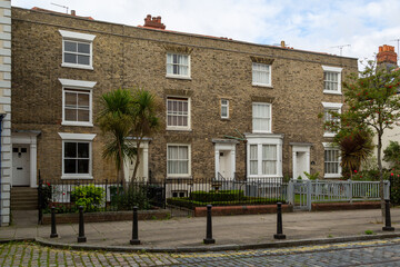 A row of Victorian terraced houses in old commercial road in Portsmouth with cobbled streets, the street that Charles Dickens was born on