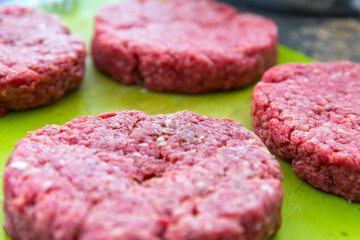 Raw beef burgers close up on a chopping board