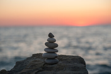 Zen stone pyramid on the seashore in the setting sun
