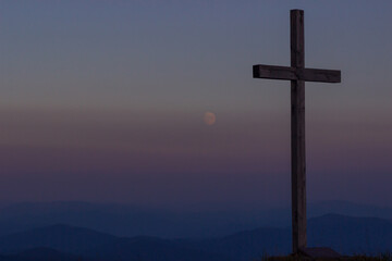 cross silhouette on the mountain at sunset