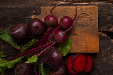 Beetroot with green tops on a wooden background. View from above. Organic healthy food, vegetables. Dark background