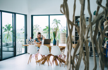 Cheerful blonde woman using digital tablet and technology on remote job and freelancing satisfied with income, smiling prosperous female happy about sales in web store shopping browse web page