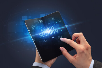 Businessman holding a foldable smartphone with SMART SECURITY inscription, cyber security concept