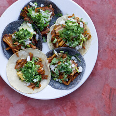 Tacos al pastor servidos algunos con tortilla de maíz azul