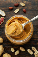 peanut paste in an open jar and peanuts in the peel