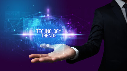 Man hand holding TECHNOLOGY TRENDS inscription, technology concept