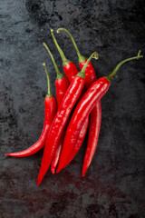 Pods of red chili peppers on a dark background