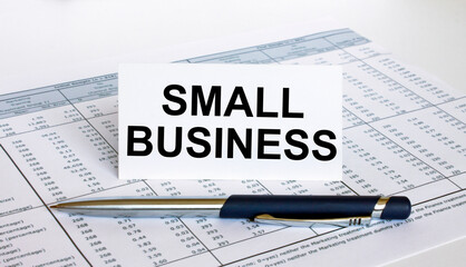 Text Small Business on white card with blue metal pen on financial table