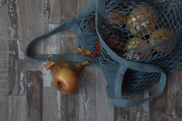 Autumn harvest shopper bag onions on aged wood background