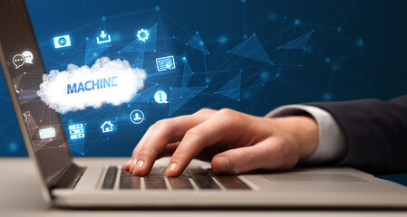 Businessman working on laptop with MACHINE inscription, modern technology concept