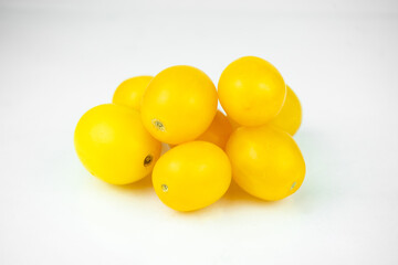 Batch of yellow fresh tomatoes isolated on white background