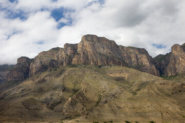 Unusual mountain rocky landscape, sheer cliffs against the backdrop of a cloudy sky