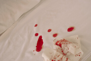 blood stains in bed and a bloody napkin