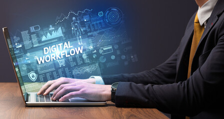 Businessman working on laptop with DIGITAL WORKFLOW inscription, cyber technology concept