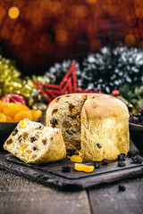 Slice of delicious panettone with candied fruits with blinking blurred Christmas lights, bread with fruits
